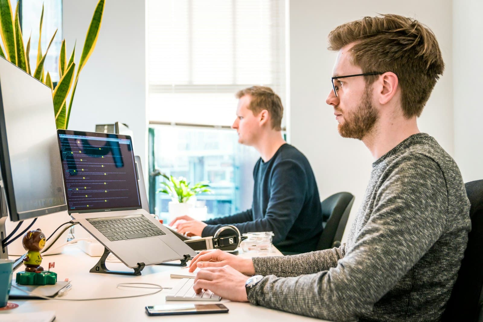 Software engineers building a healthcare application together at laptops